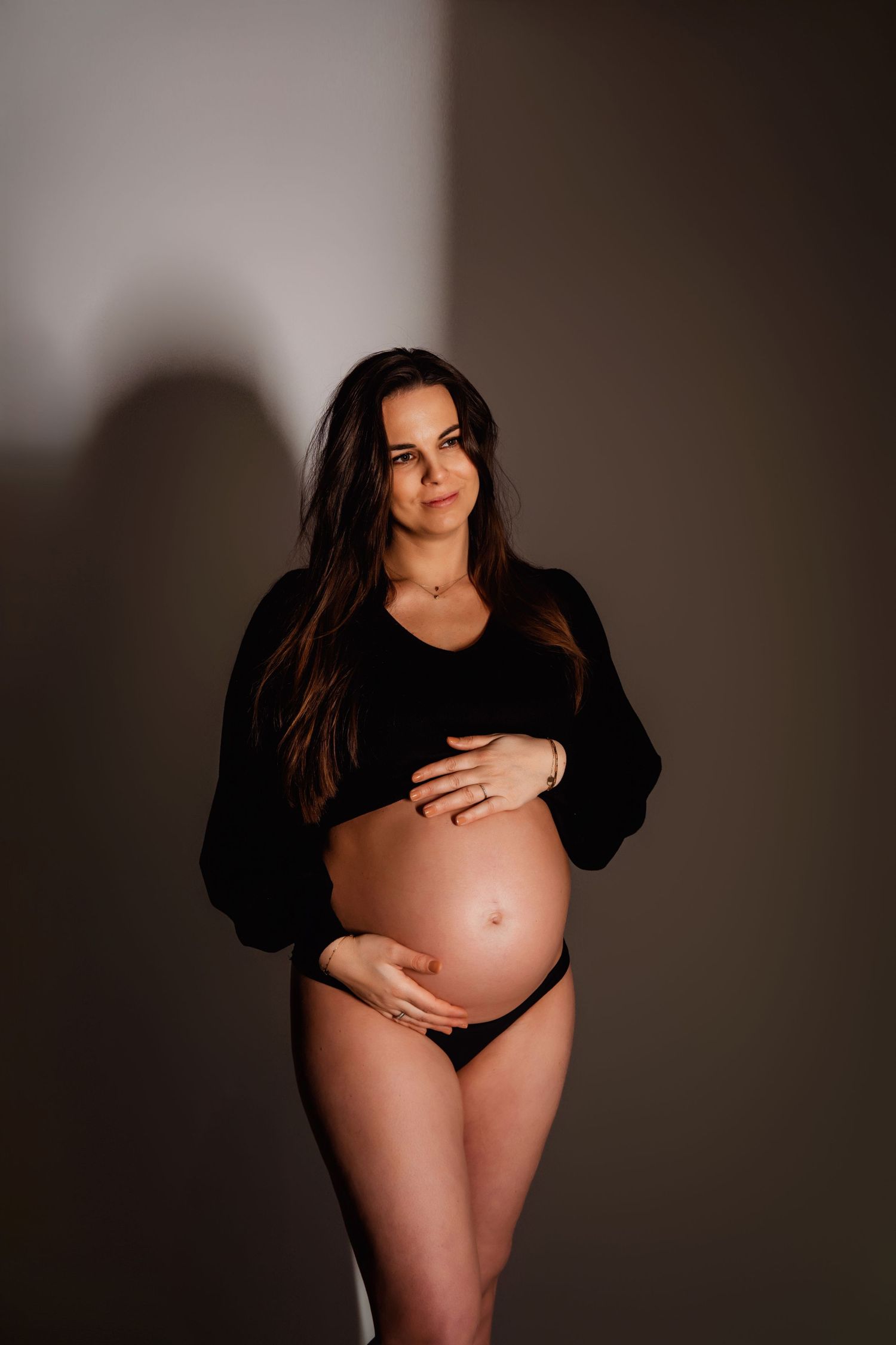Intieme zwangerschapsboudoirfoto’s in donkere, sfeervolle belichting, zwangerschapsfotografie Brabant