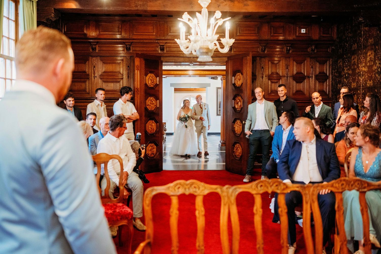 Trouwceremonie in stijlvolle houten zaal met kroonluchter, romantische bruidsfotografie in Den Bosch en omgeving Brabant.