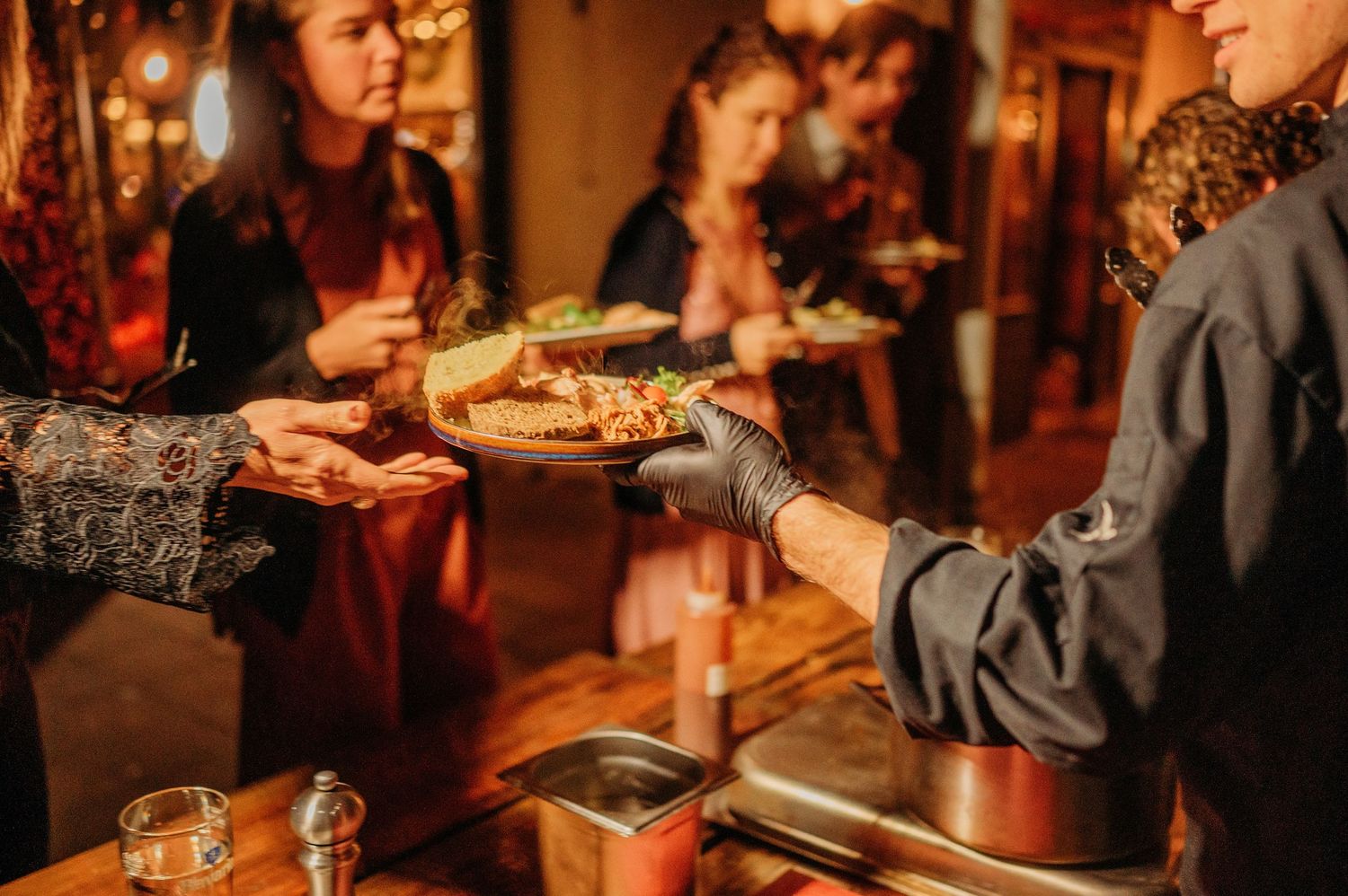 Bruiloftsgasten genieten van diner en gesprekken, sfeervolle bruidsfotografie bij Boscafé Oisterwijk, regio Brabant.