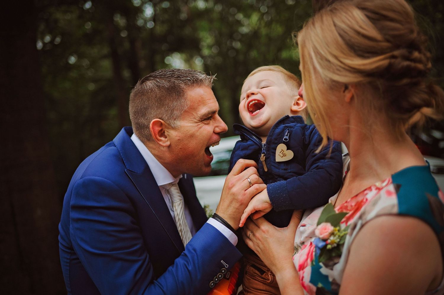 Vader speelt met kind tijdens bruiloft in Brabant, spontane en emotionele bruidsfotografie