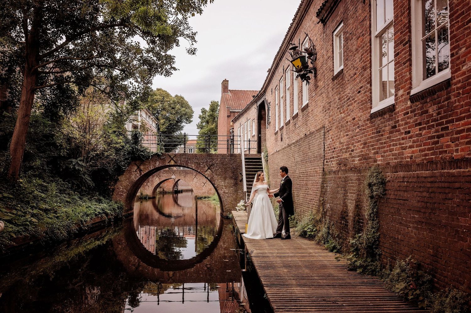 Historisch bakstenen steegje met bogen vormt een romantisch decor voor trouwfoto, bruidsfotografie Brabant