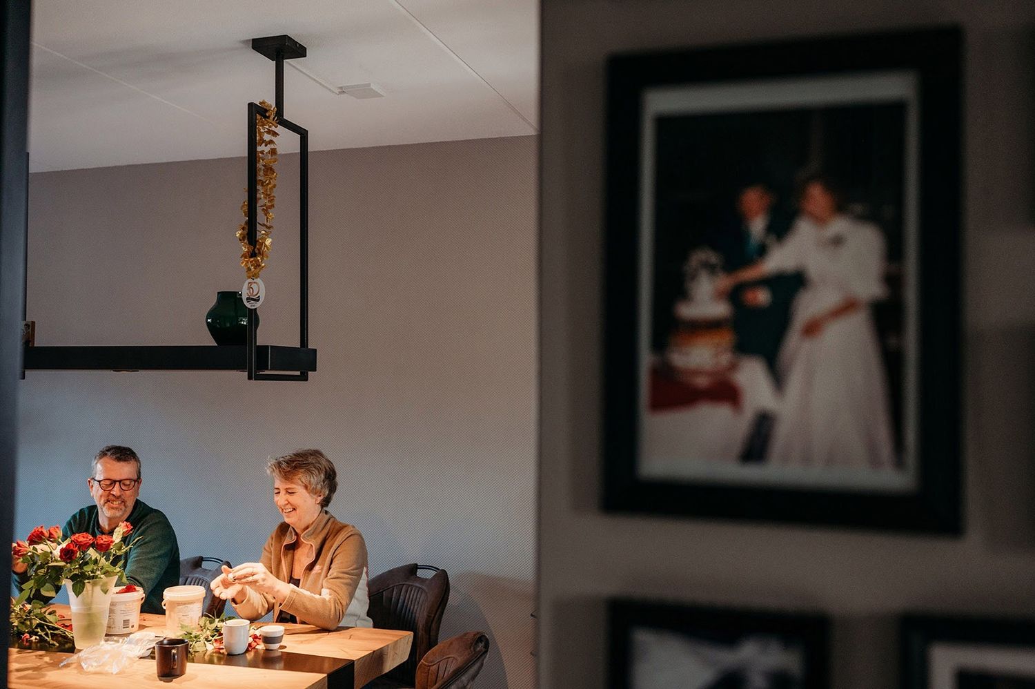 Indoor trouwreceptie met gasten zittend aan tafels tijdens avondviering, bruidsfotografie Brabant