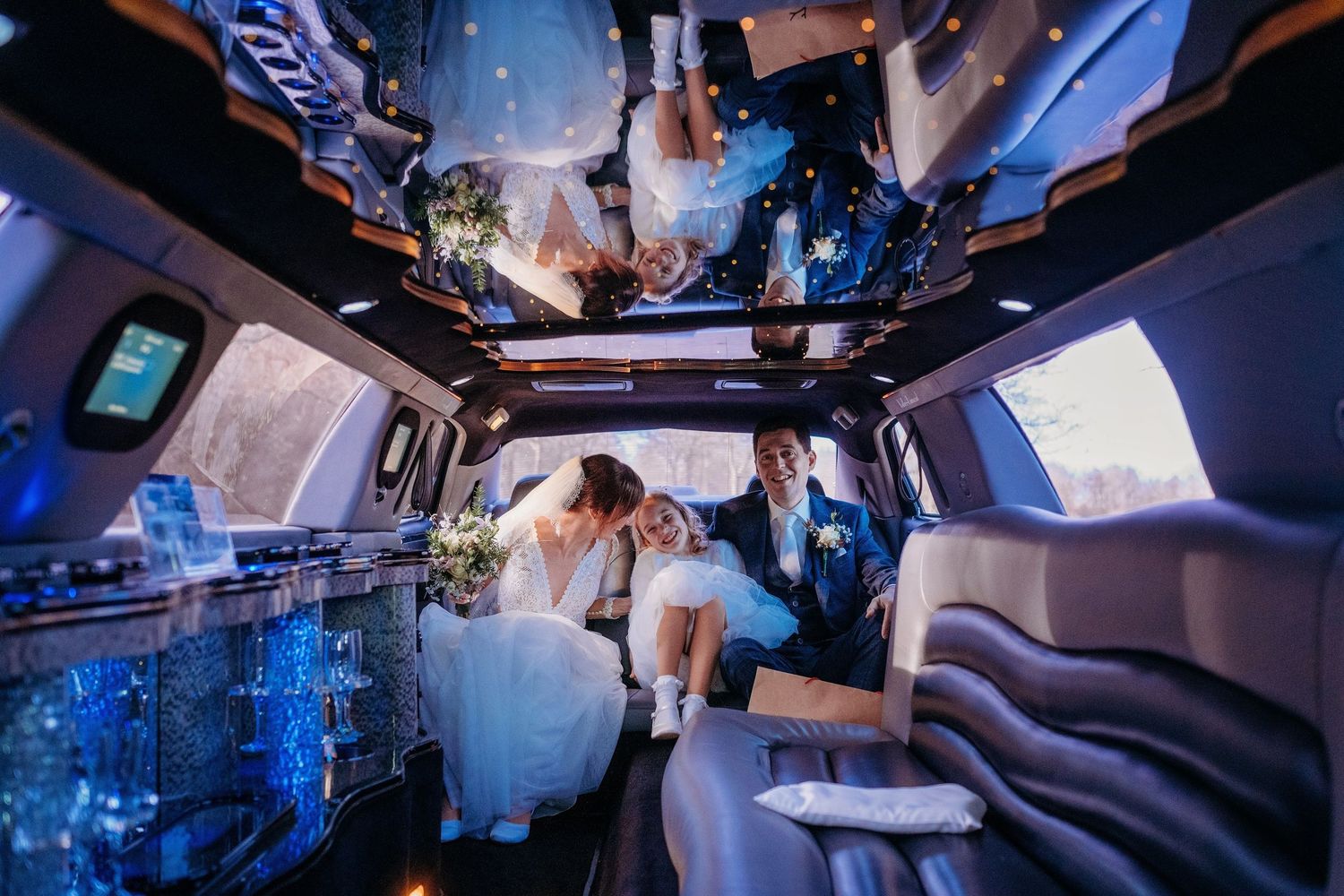 Interieur van limousine met blauwe verlichting tijdens nachtelijke bruiloftstransport, bruidsfotografie Brabant.