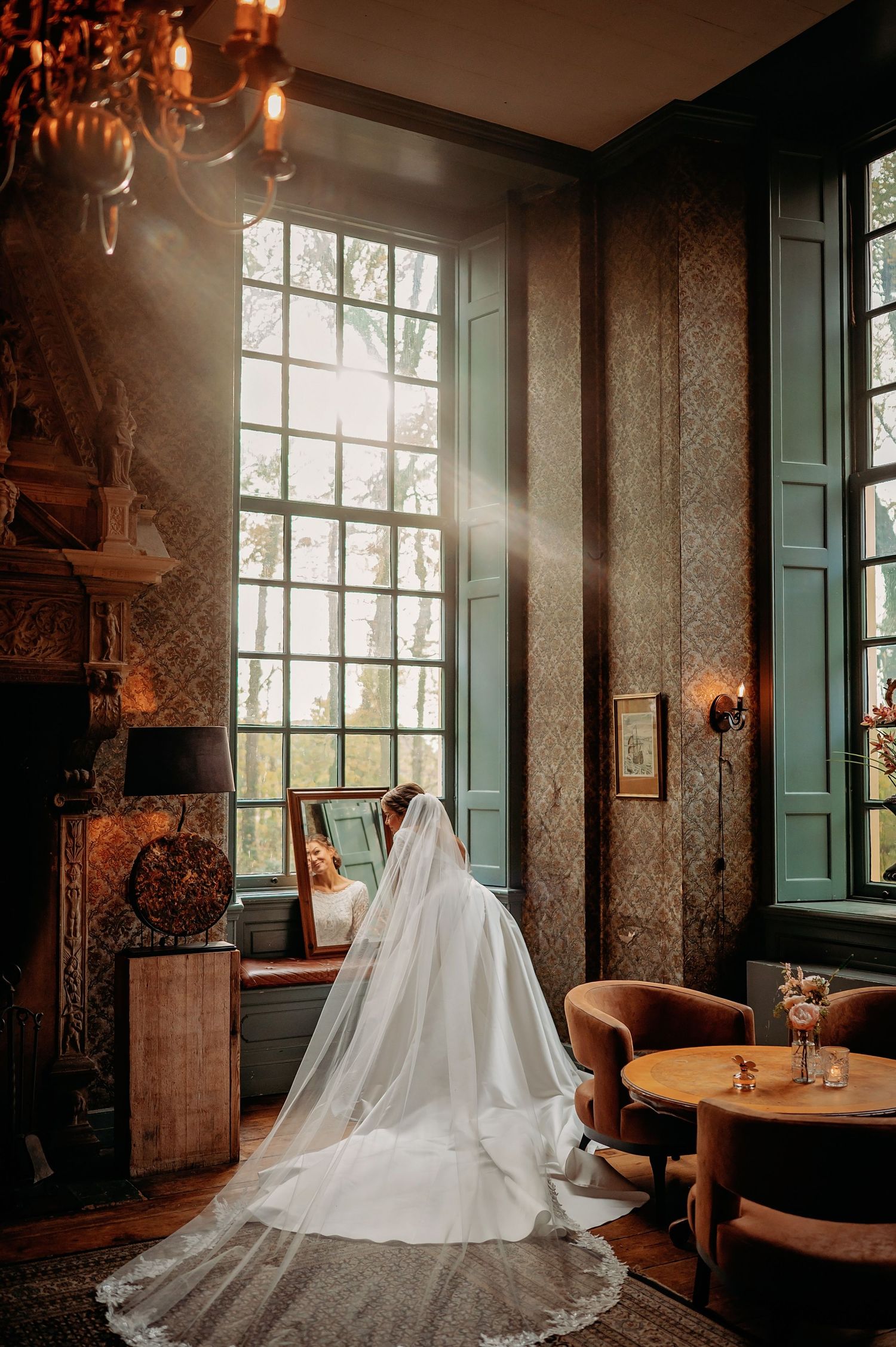 Elegante trouwjurk in vintage kamer met grote ramen en ornamenten, bruidsfotografie Brabant