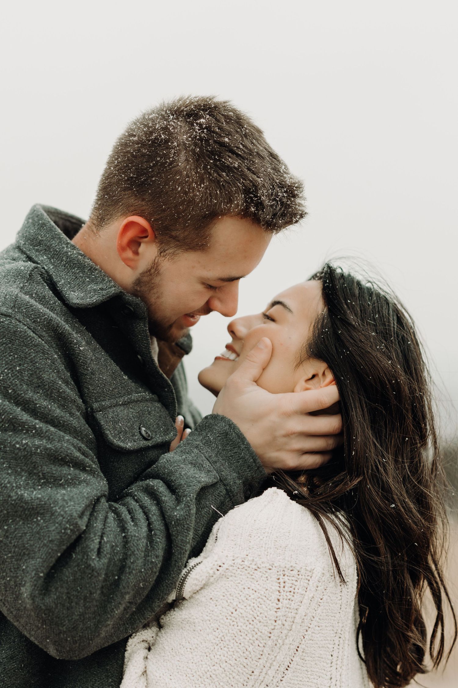 Romantic couple sharing intimate moments in a series of tender kisses while wearing grey and white clothing.