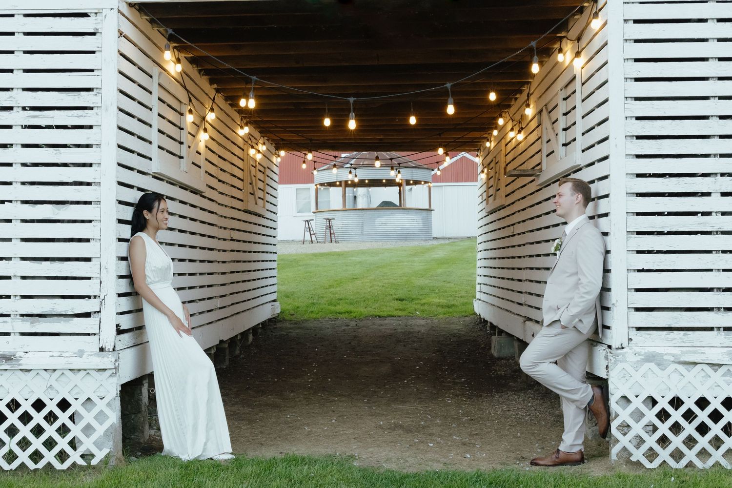 String lights illuminate a rustic barn interior decorated for an elegant wedding celebration.