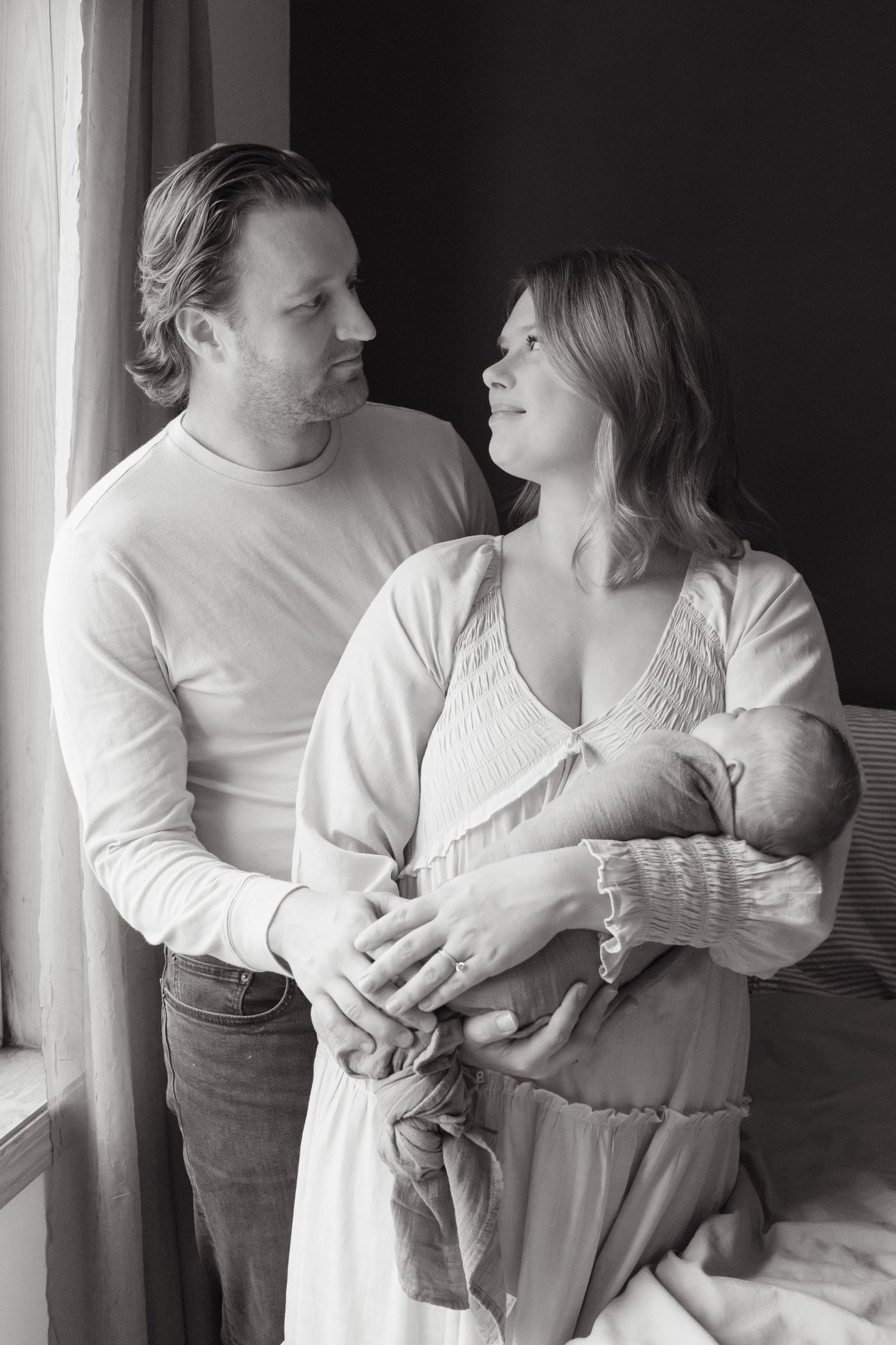 A series of intimate black and white photos showing tender moments between a couple embracing.
