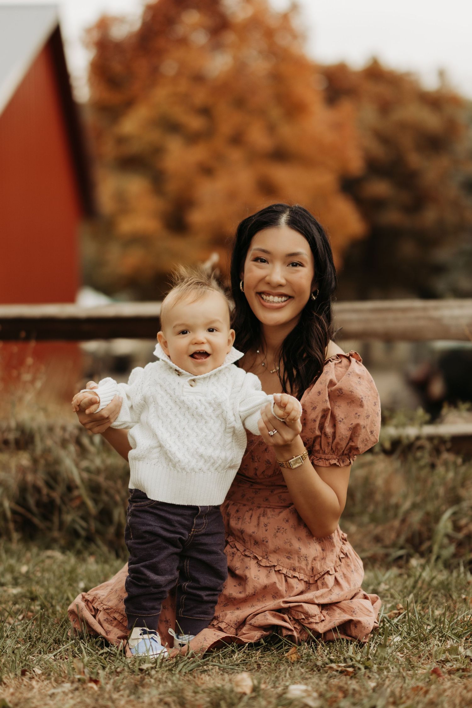 Sweet outdoor moment between parent and child sitting on grass during fall season.