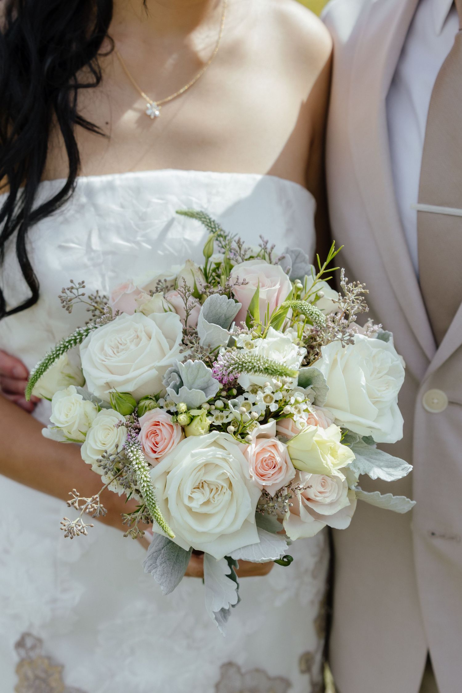 A delicate wedding corsage featuring white roses, pink blossoms, and greenery displayed in multiple angles.