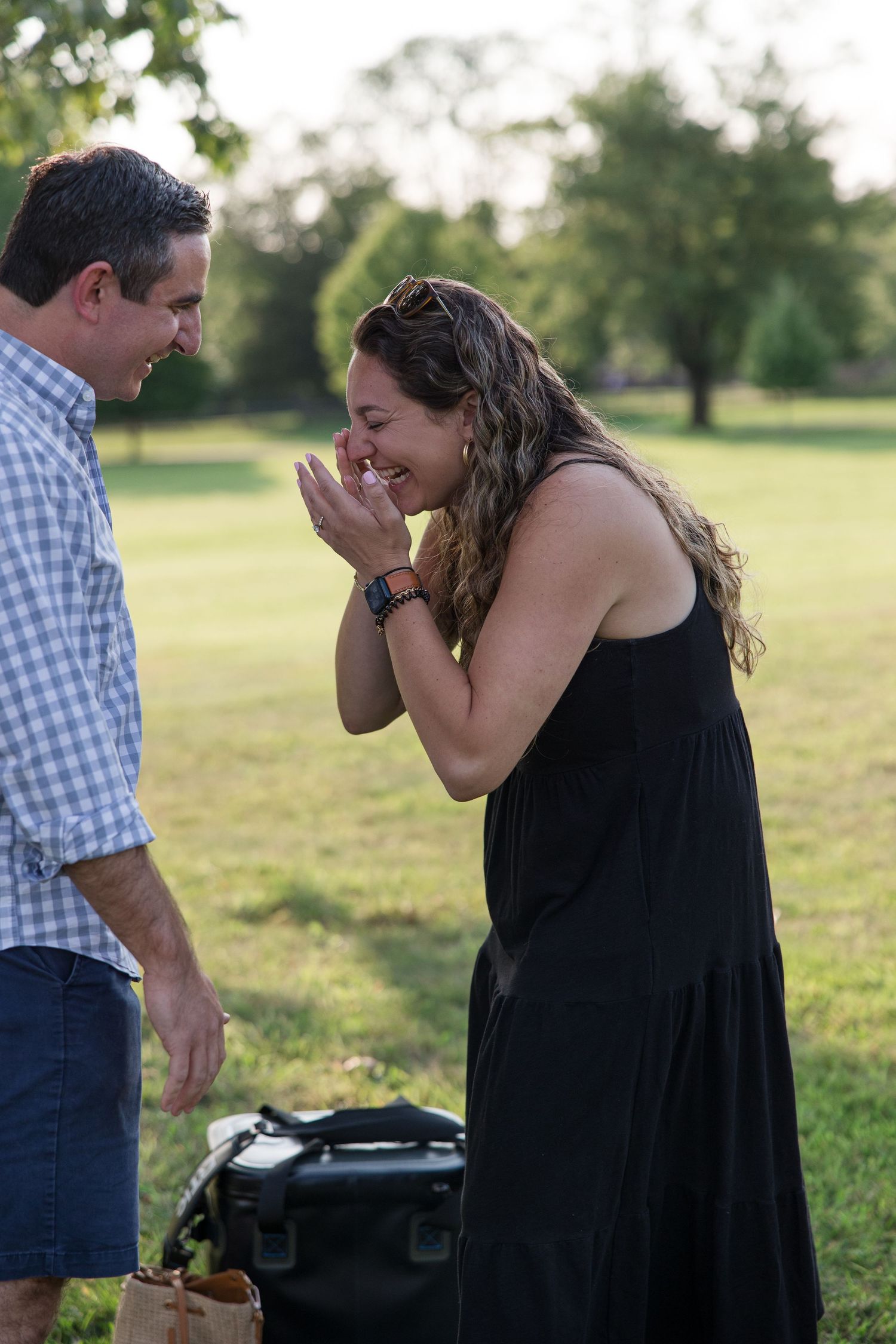 An emotional reaction captured in a park setting with sunlight filtering through trees.