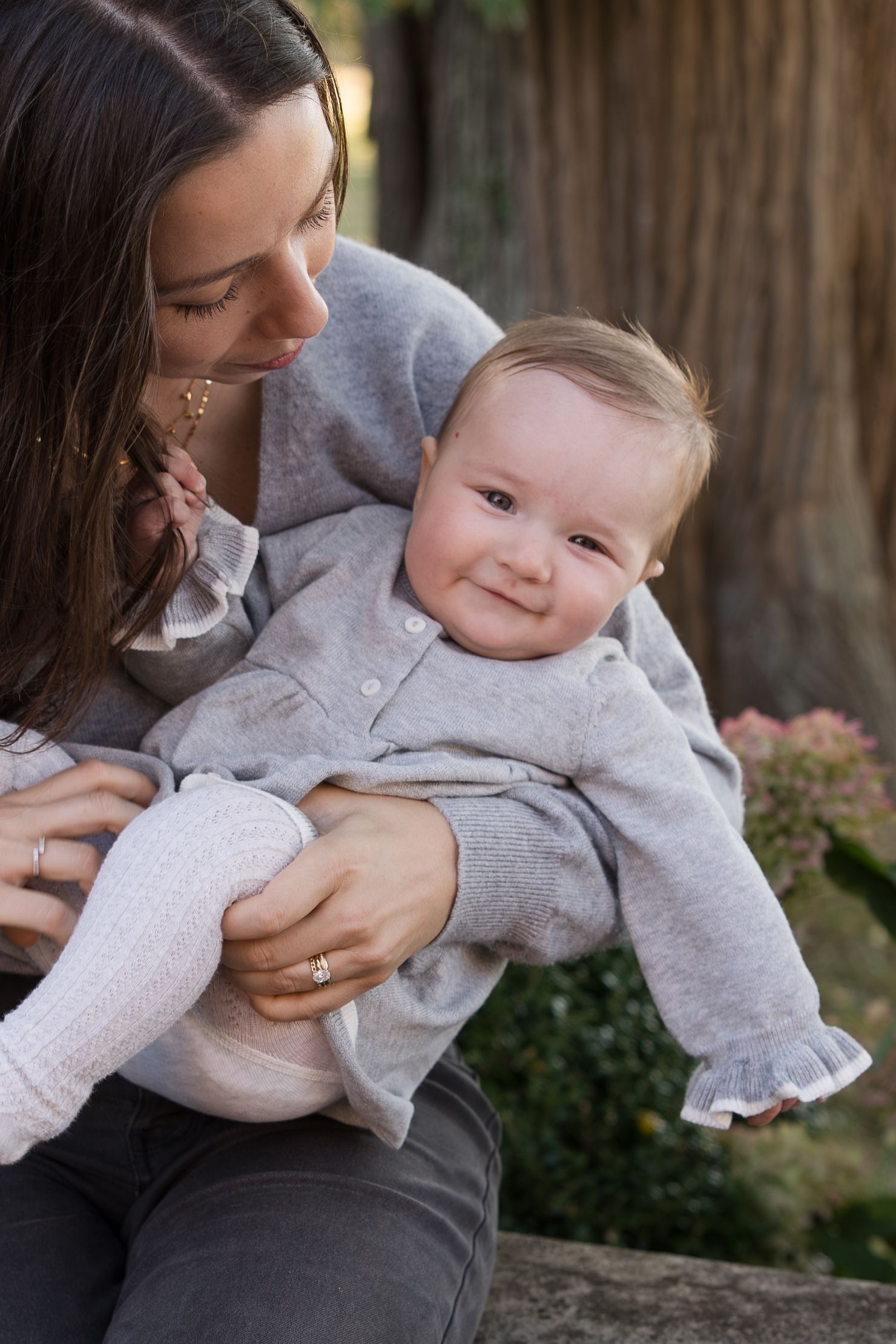 Tender moment between mother and baby in casual outdoor portrait session.