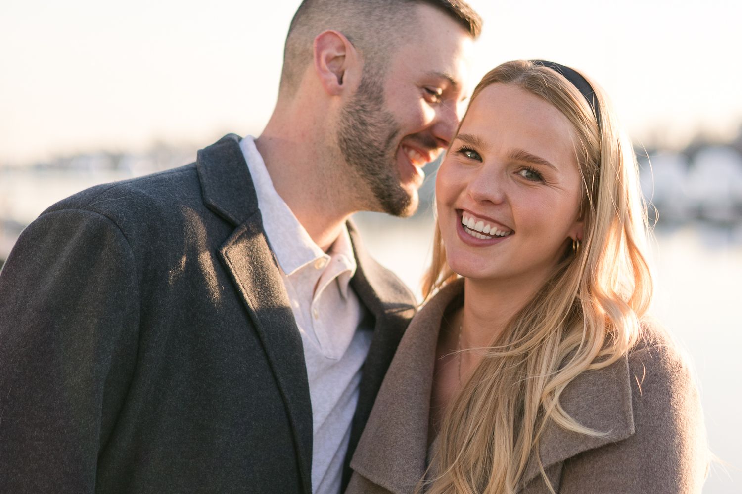 A romantic couple sharing a tender moment at sunset with soft golden lighting.