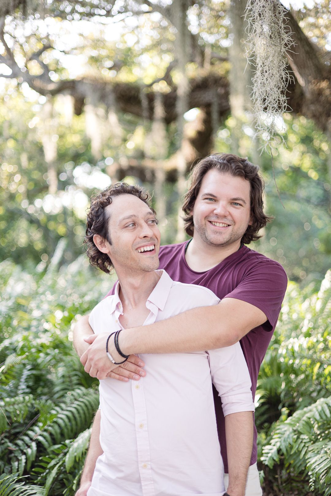 Two people sharing a joyful moment among lush tropical foliage.
