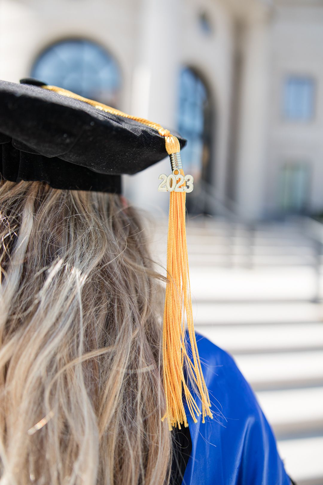 Close up of 2023 graduation tassel against courthouse background.