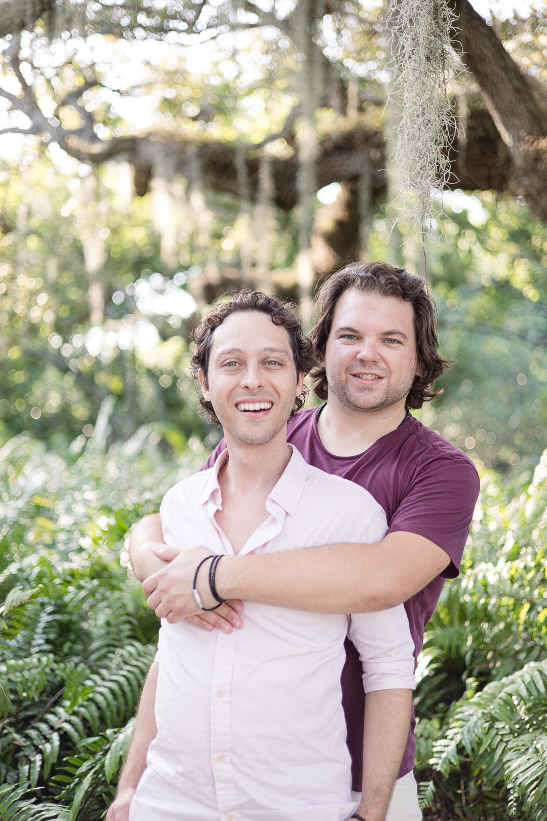 Two people sharing a warm embrace while standing in a lush garden setting.