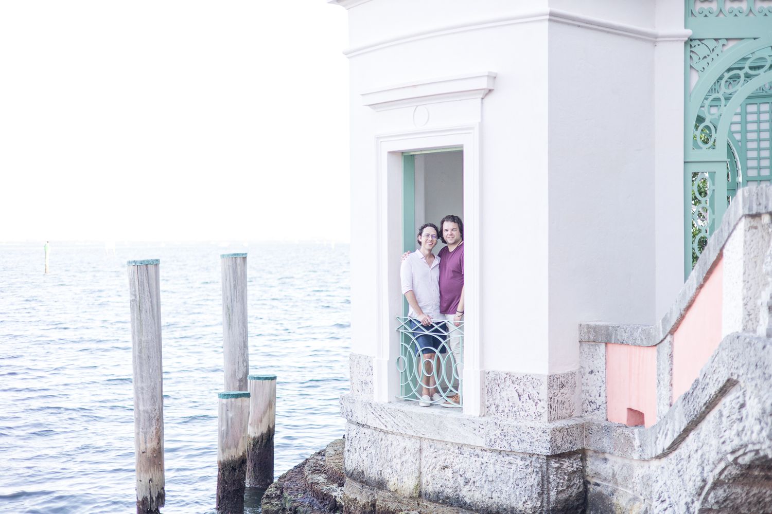 Seaside gazebo overlooking the ocean with ornate white pillars and turquoise accents.