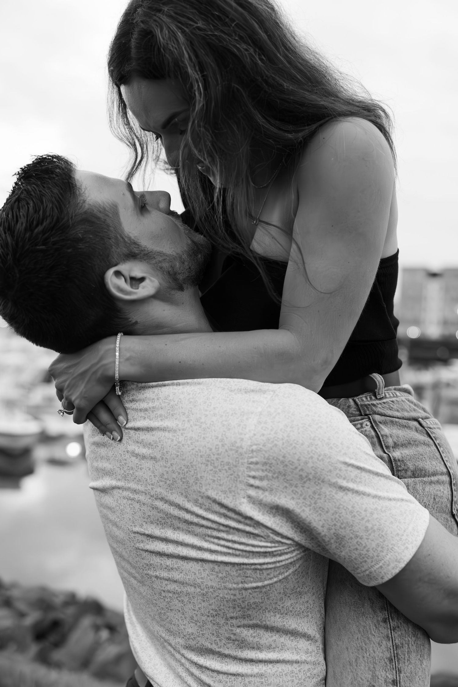 A romantic black and white photograph of a couple embracing and kissing.