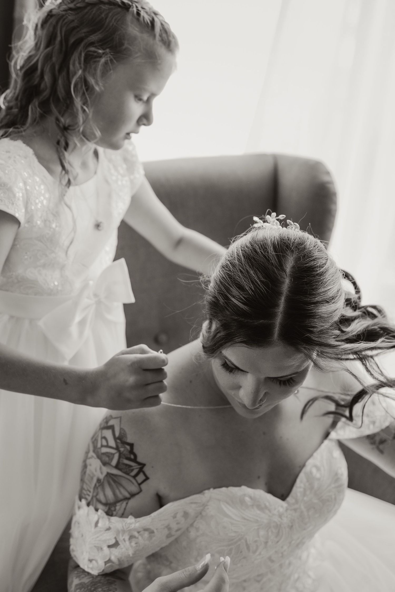 Black and white photo of wedding preparation with delicate dress details.