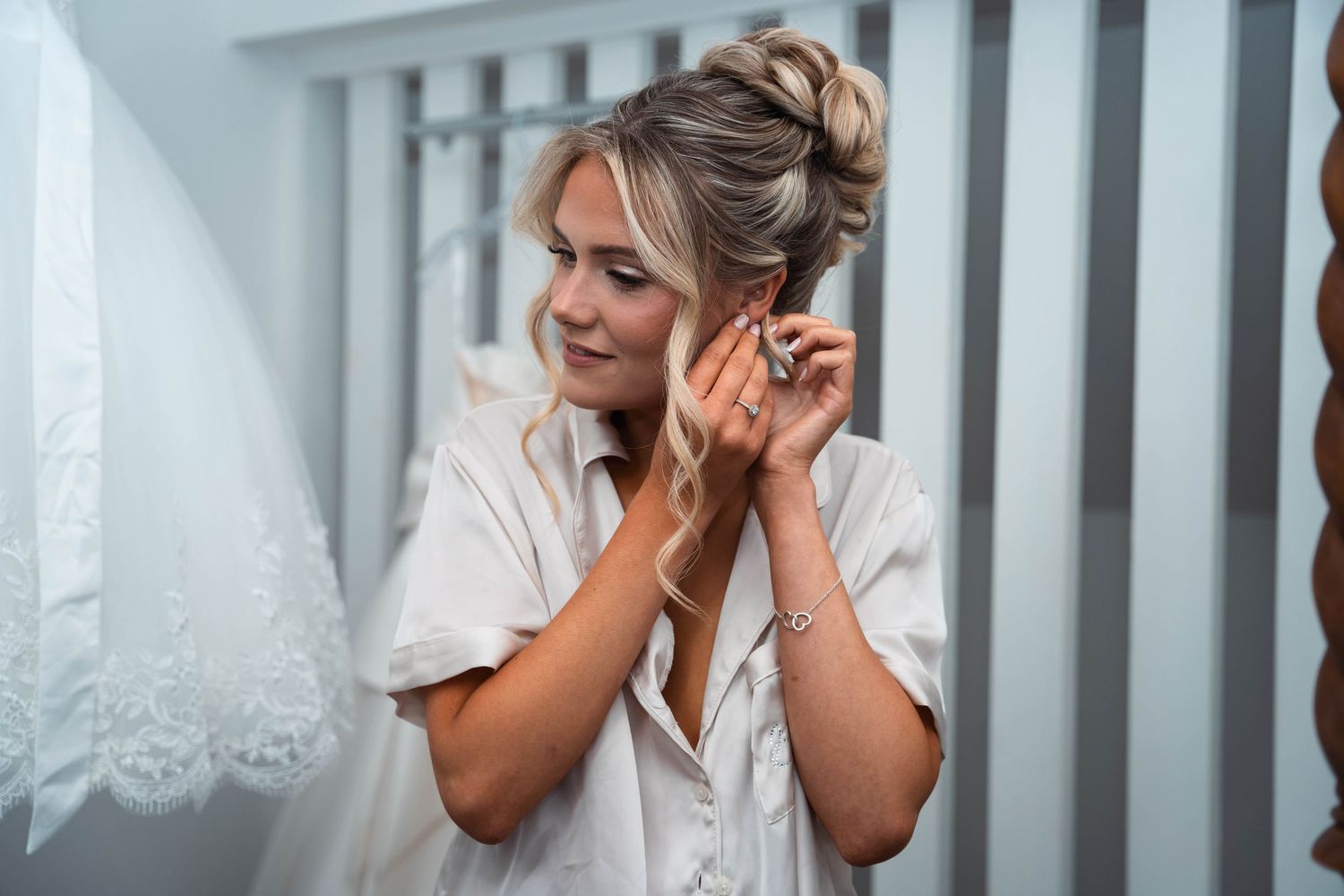 Bride putting in her earrings at The gardeners country inn, captured by a candid wedding photographer.