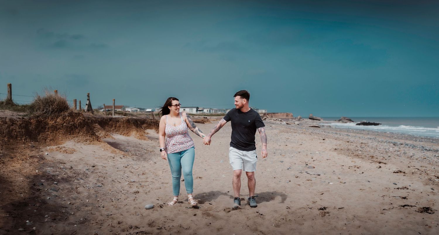 Couple walking and smiling during their engagement shoot, taken by a Yorkshire wedding photographer in Hull