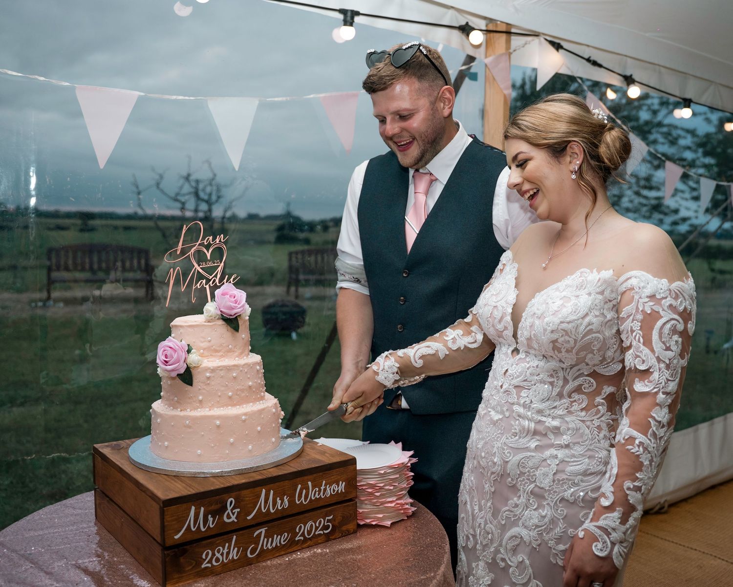 Bride and groom cutting their cake at their home farm wedding, Captured by a documentary east Yorkshire photographer