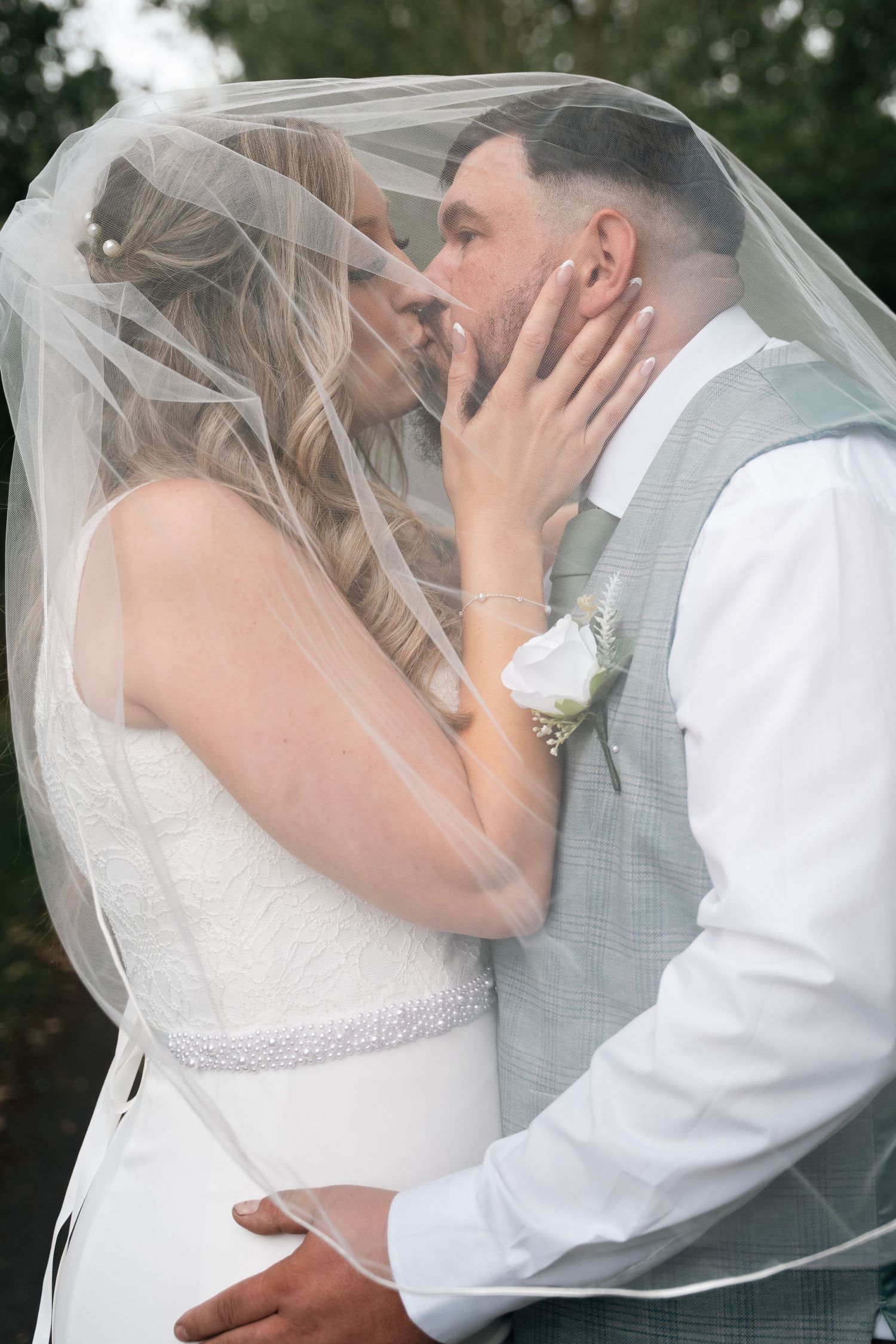 Bride and groom sharing a kiss under the veil at The Gardeners Country inn, captured by a documentary wedding photographer in East Yorkshire