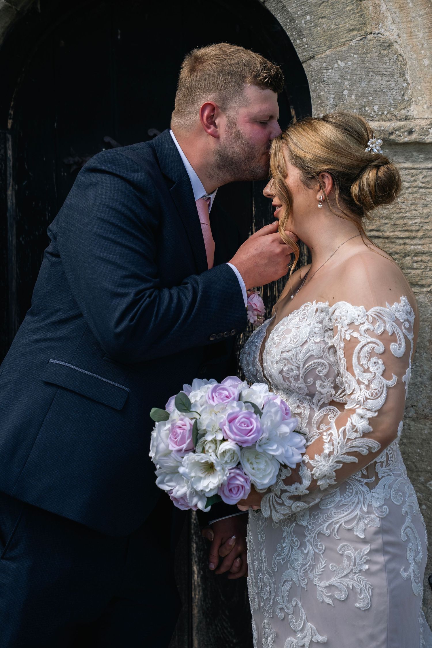 Bride and groom sharing a kiss at St Elgin's church in North Frodingham, captured by a Hull Wedding photographer