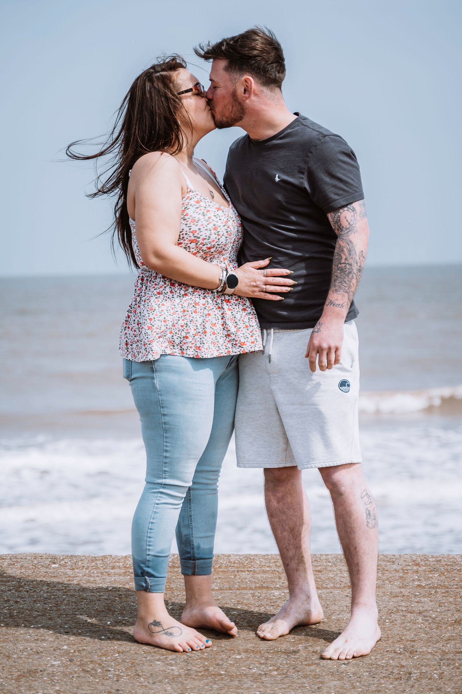Couple kissing on the beach during their engagement shoot, taken by a Yorkshire wedding photographer in Hull