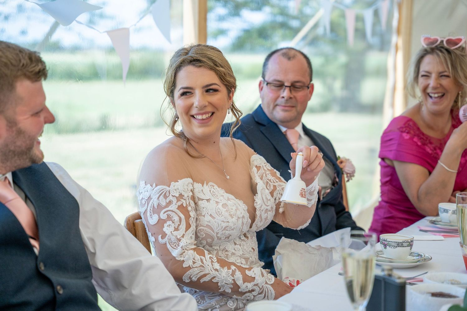 Bride with a gift she received during the speeches at their tipi wedding on their own land, captured by East yorkshire wedding photographer