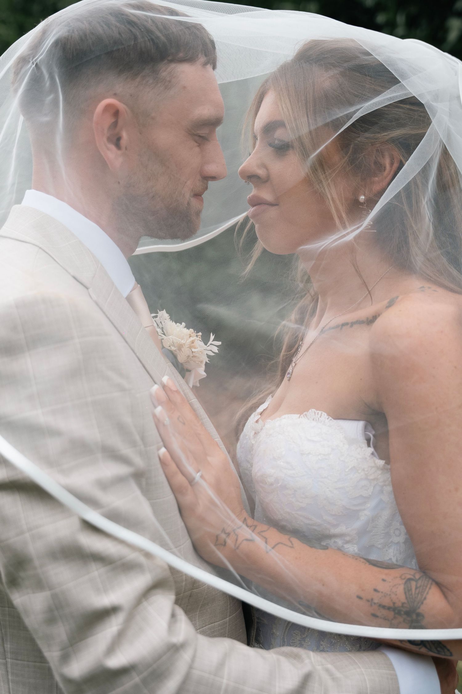 Bride and groom sharing a kiss under the veil at Lazaat hotel in Cottingham