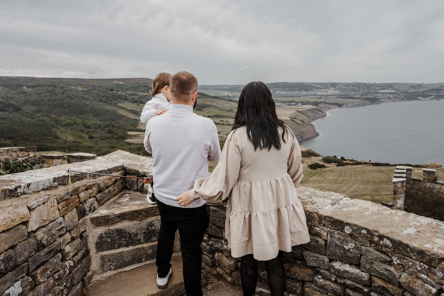 Family looking over the sea during their engagement shoot, taken by a Yorkshire wedding photographer at Grand villa heights