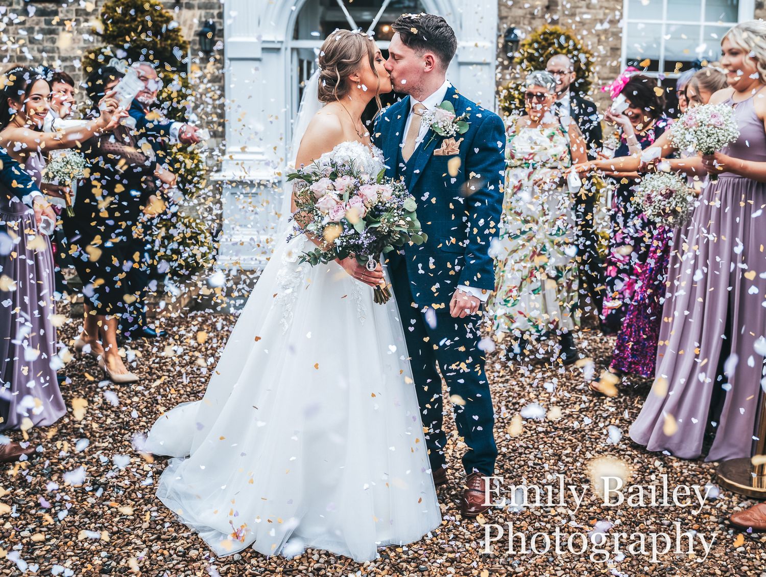 Bride and groom walking through falling confetti after their wedding ceremony at Dunedin Country House.