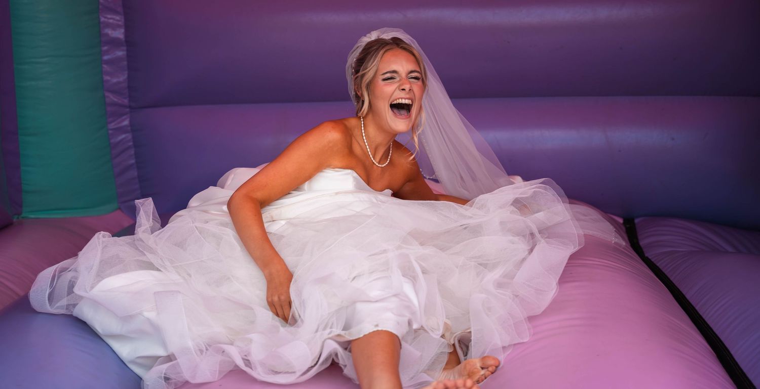 Bride laughing after falling on a bouncy castle at Gardeners Country Inn – captured by East Yorkshire wedding photographer