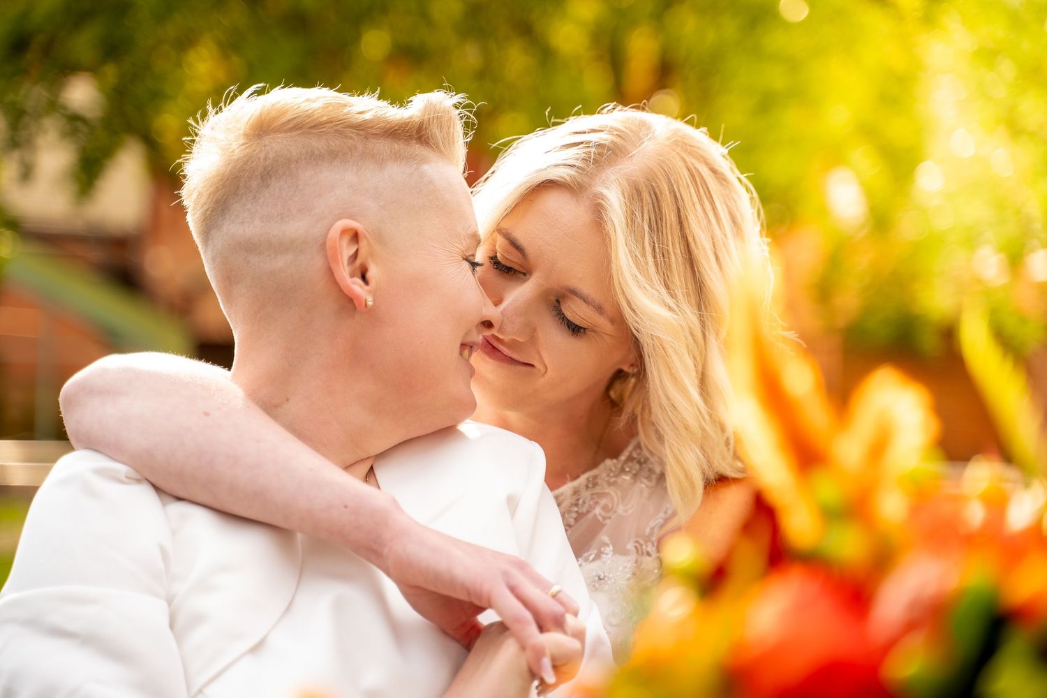 Bride and bride, hugging each other during a golden sun at The guildhall in Hull, captured by a candid wedding photographer