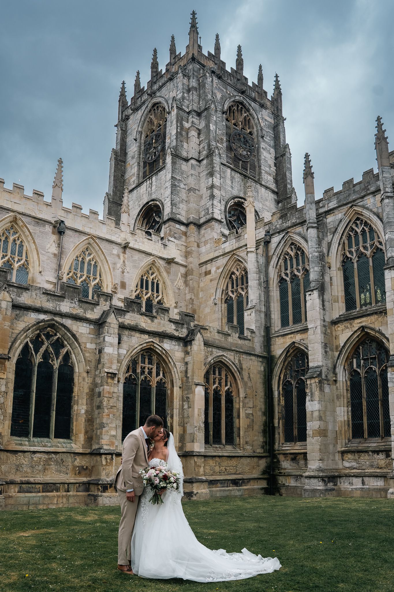 Bride and groom embracing outside St Mary's Church, Beverley after their wedding ceremony.