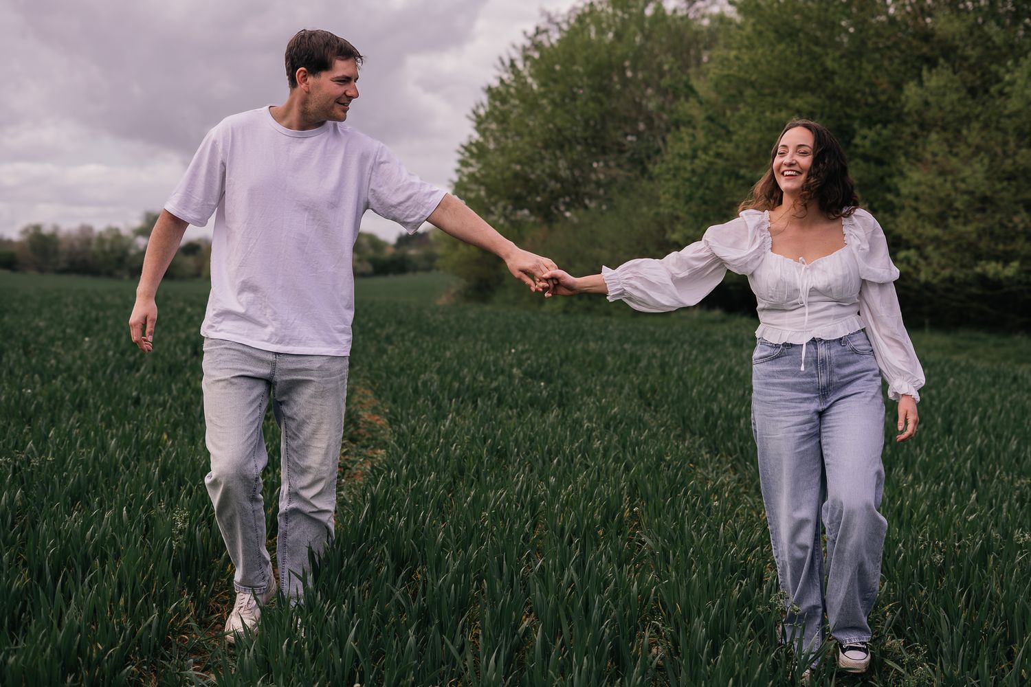 couple laughing and walking during their engagement shoot, taken by a Yorkshire wedding photographer In east Yorkshire