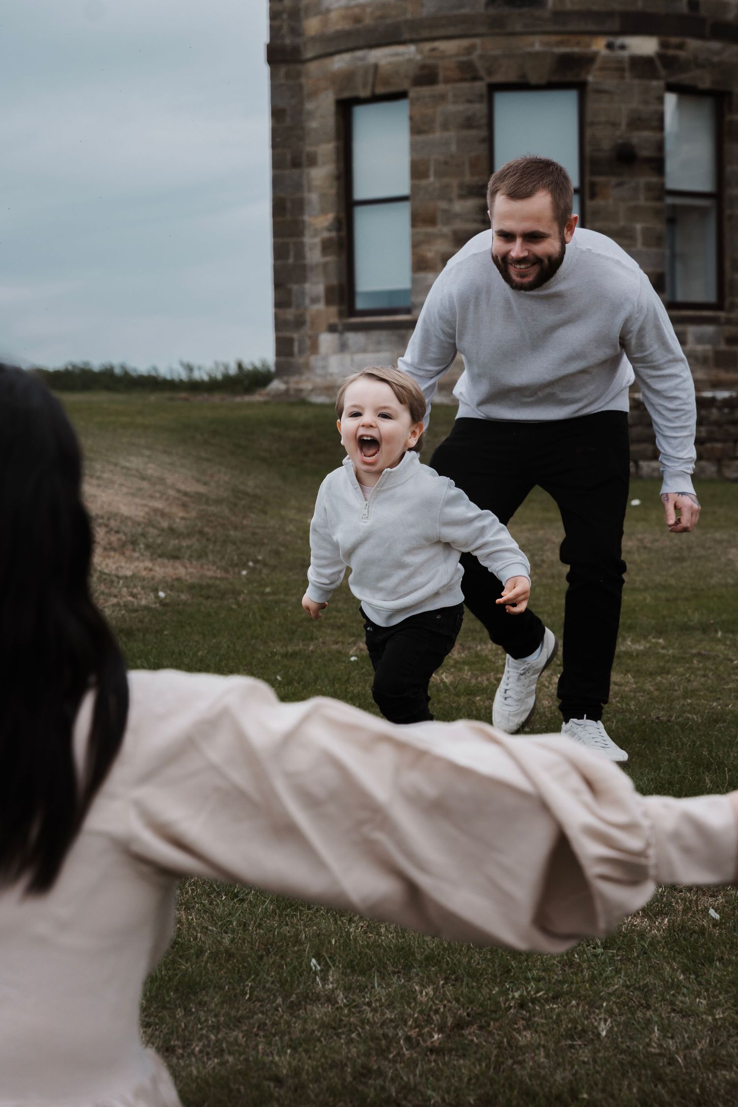 Family laughing and having fun during their engagement shoot, taken by a Yorkshire wedding photographer at Grand villa heights