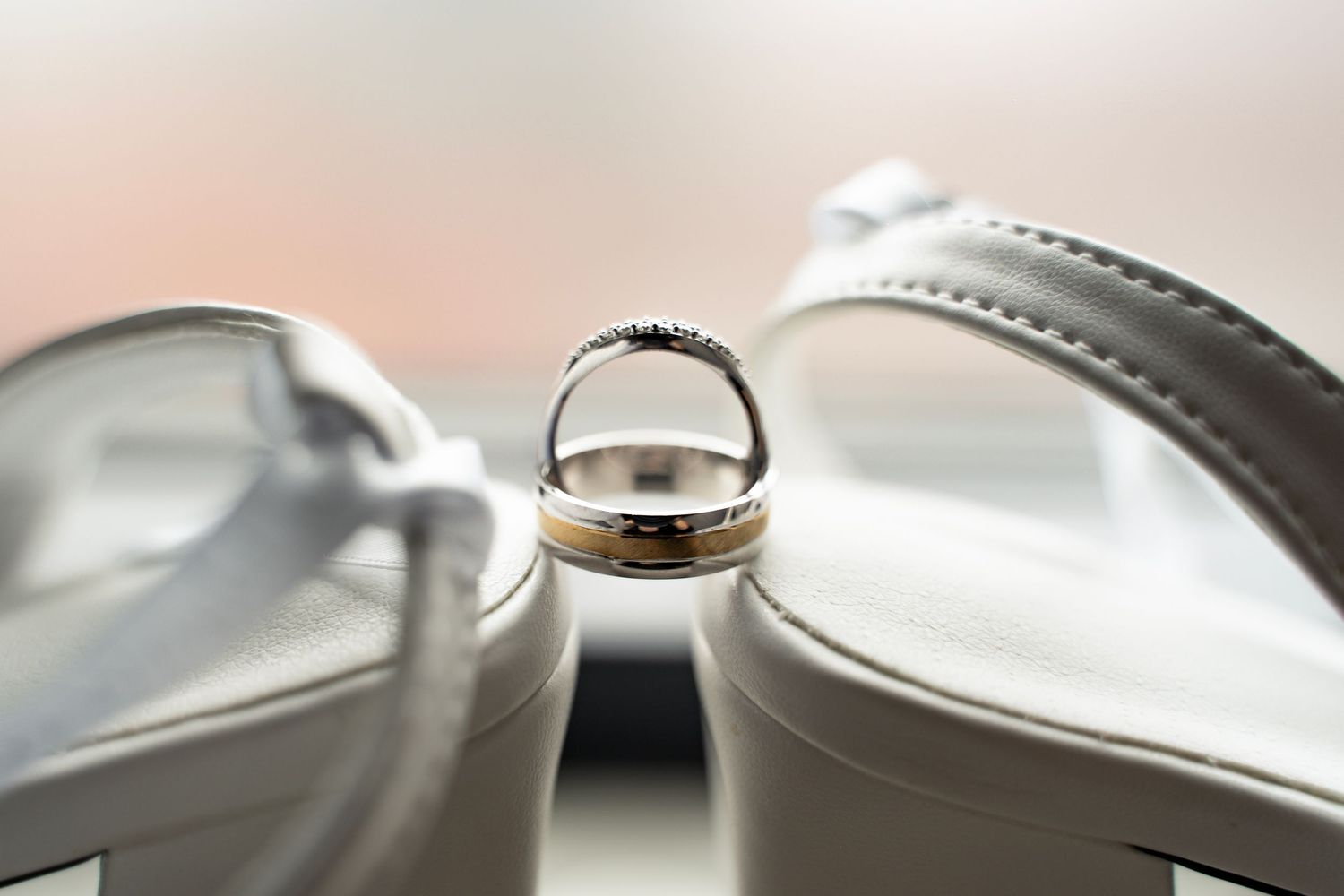 wedding rings balanced on wedding shoes, taken at Lazaat Hotel in Cottingham, captured by a candid wedding photographer in East Yorkshire.