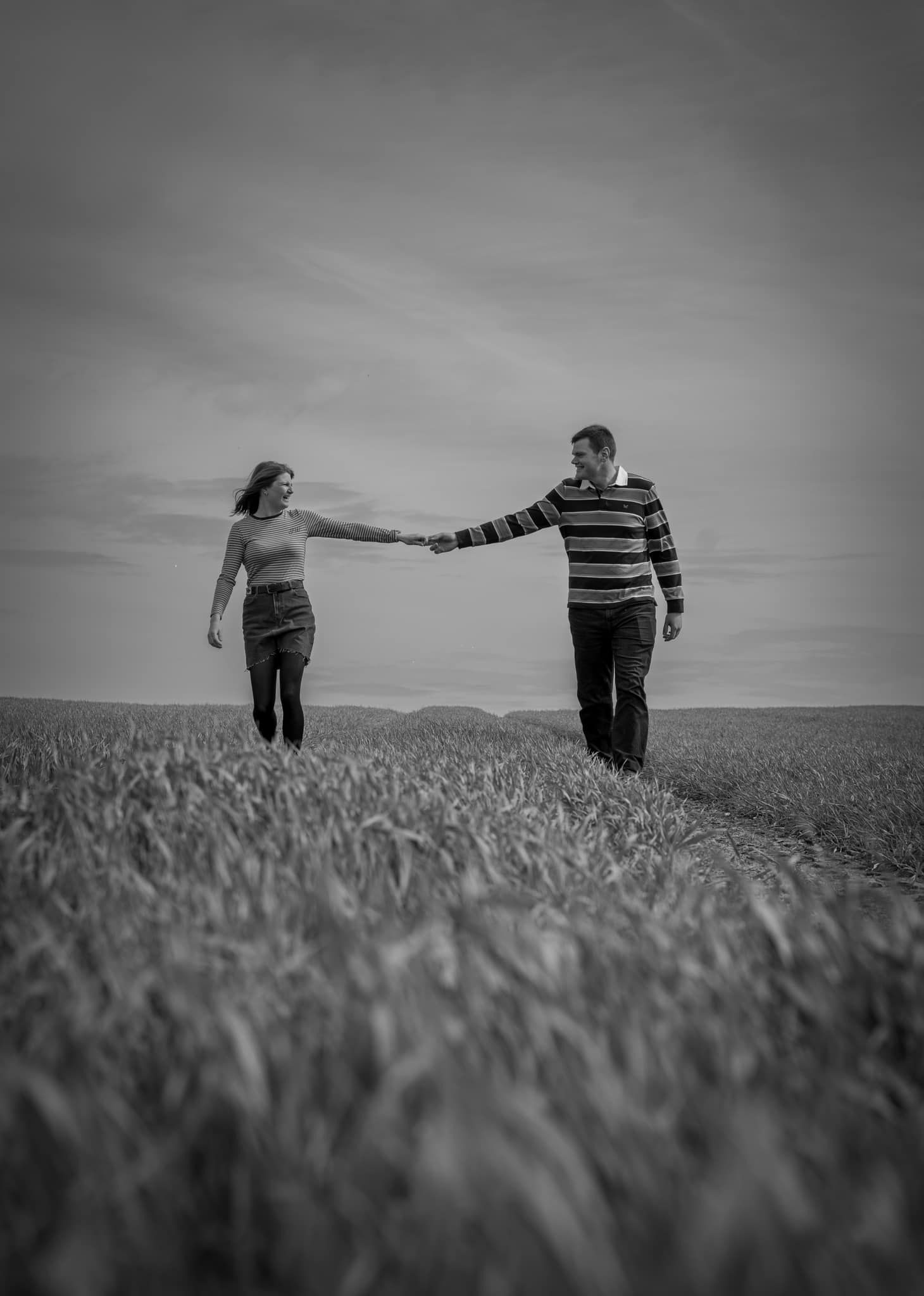 Couple holding hands and smiling during their engagement shoot, taken by a Yorkshire wedding photographer in Hull