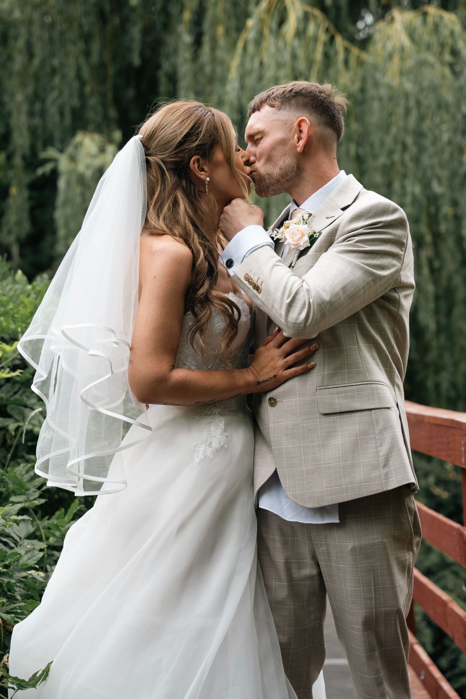 Bride and groom sharing a kiss on the bridge at Lazaat hotel in Cottingham