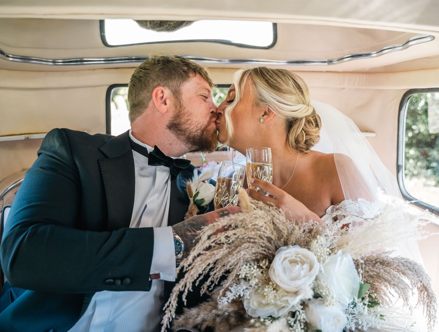 Bride & groom sharing a kiss in their wedding car and the triton inn, captured by Hull wedding photographer