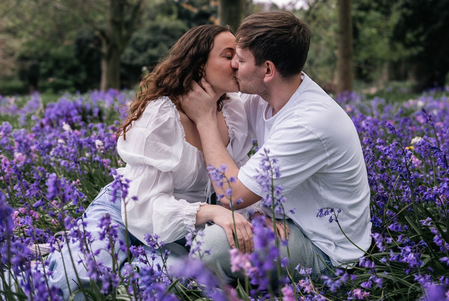 couple kissing in a bluebell field during their engagement shoot, taken by a Yorkshire wedding photographer In east Yorkshire