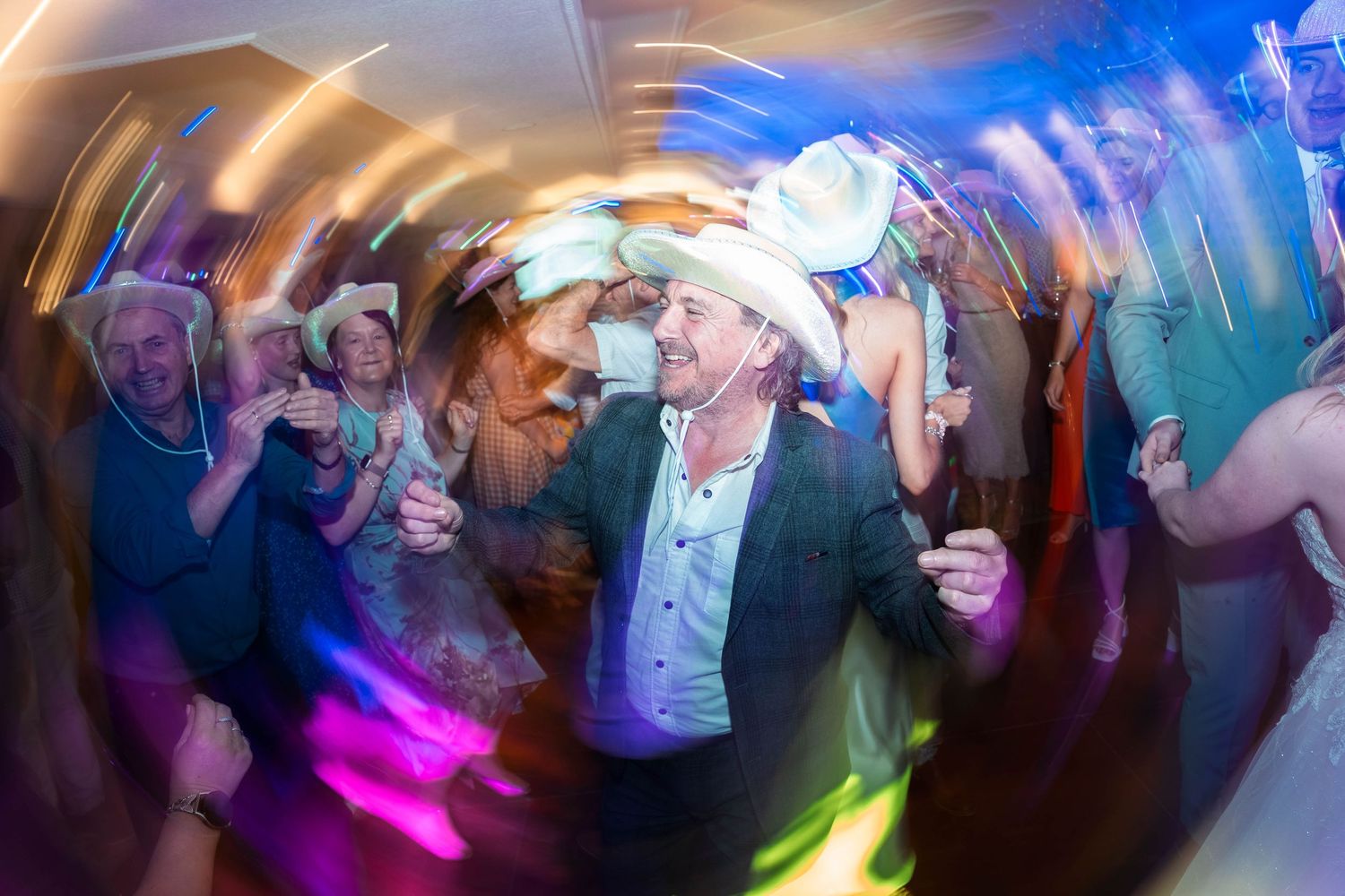 Guests in cowboy hats dancing during a wedding at The Country Park Inn, captured by a candid wedding Photographer