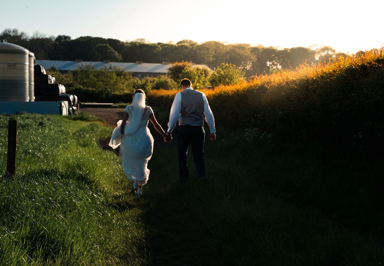 Bride and groom walking during sunset at a farm wedding in east Yorkshire, captured by a Hull wedding photographer
