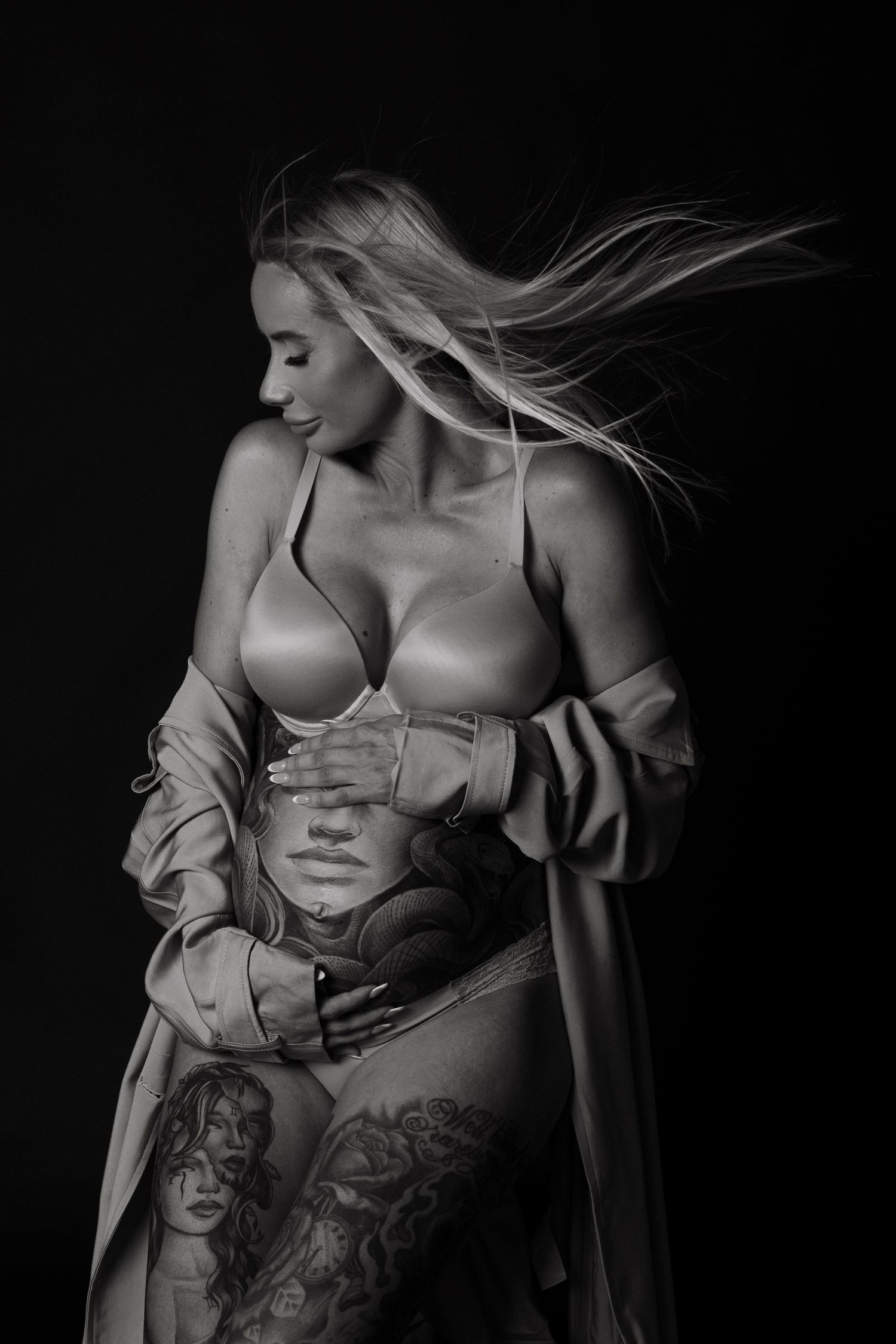 Artistic black and white boudoir photography showcasing tattoos and delicate fabric details.