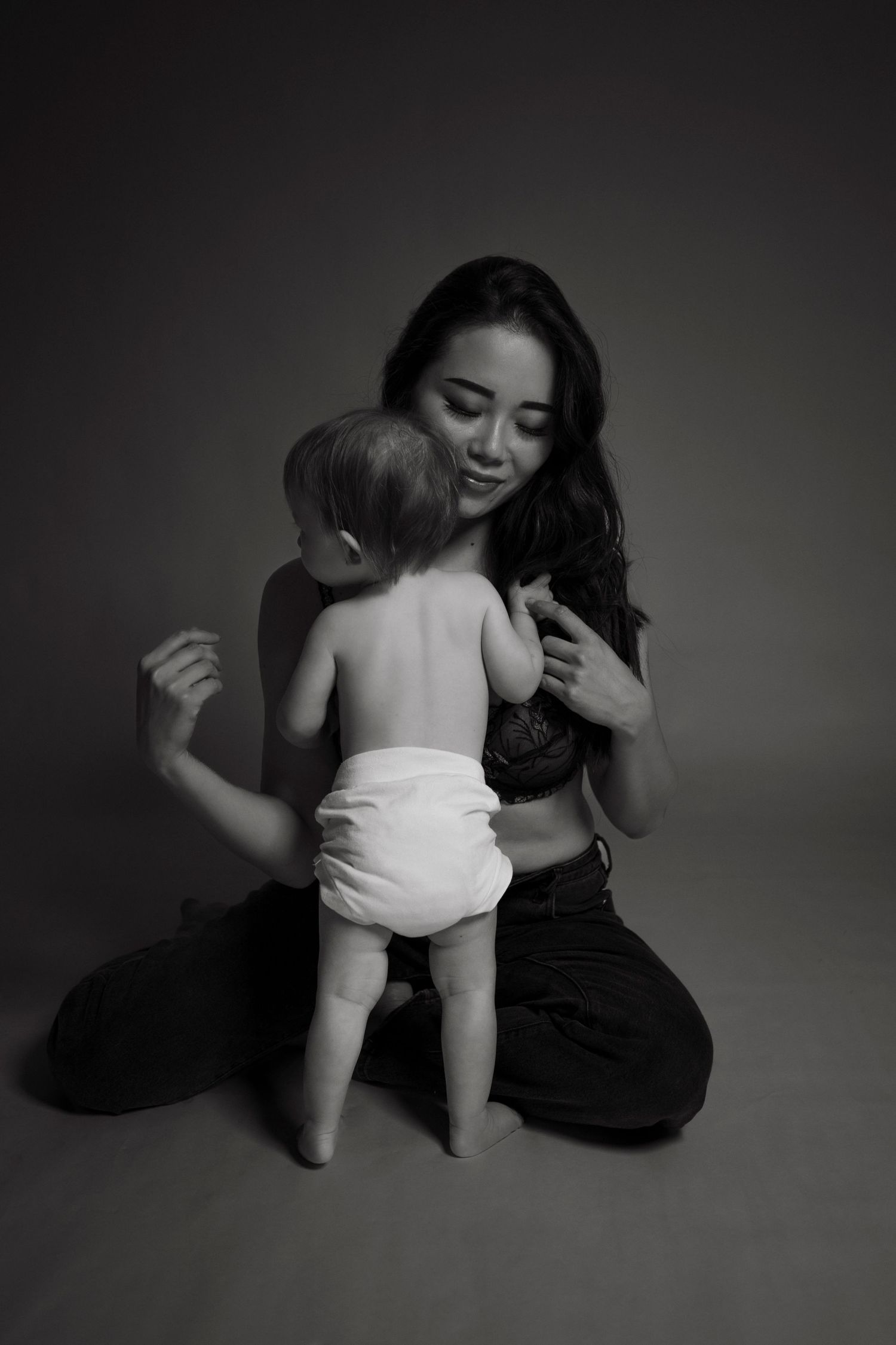 Black and white studio photos capturing playful moments between parent and child.