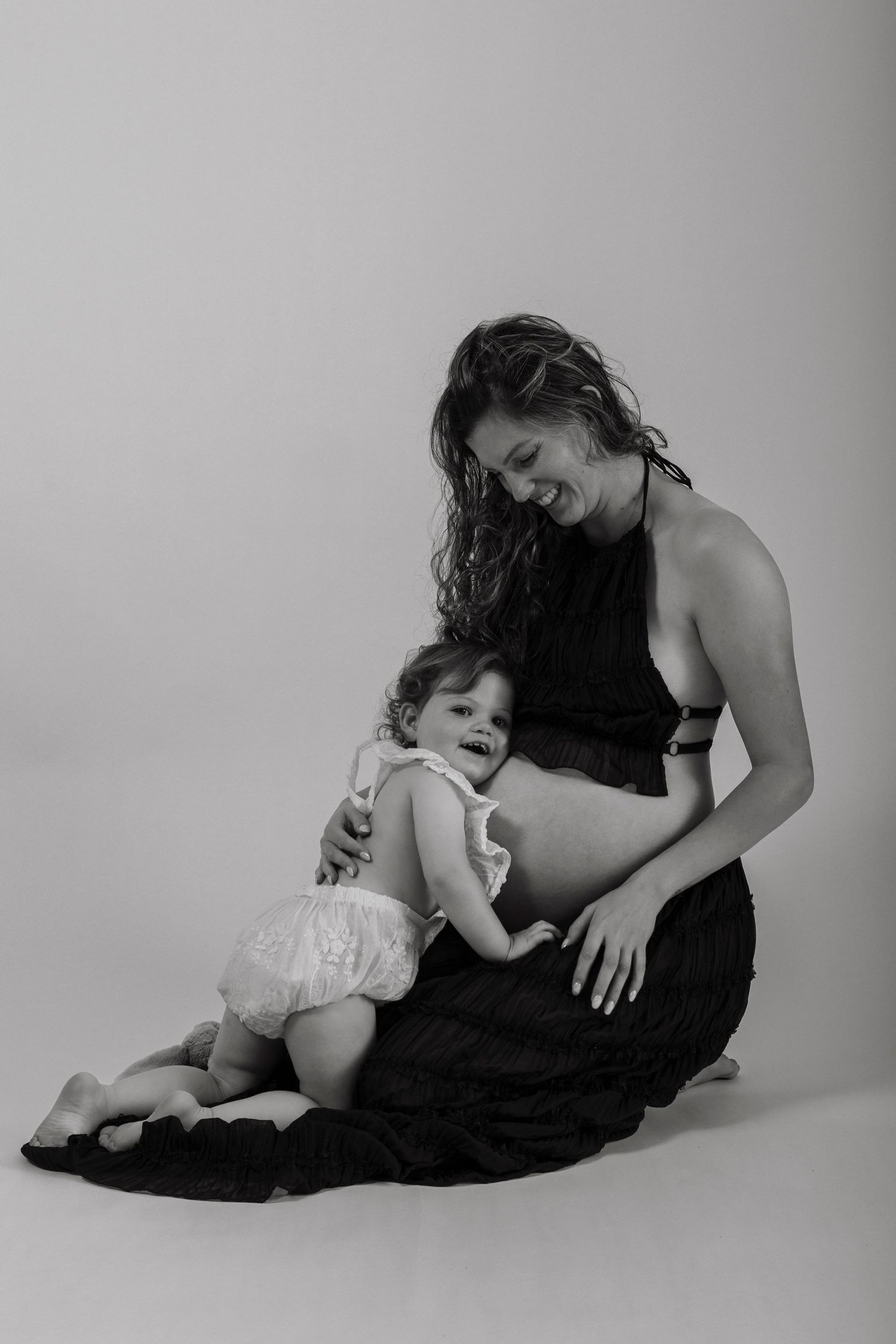 Tender black and white studio portrait showing maternal connection.