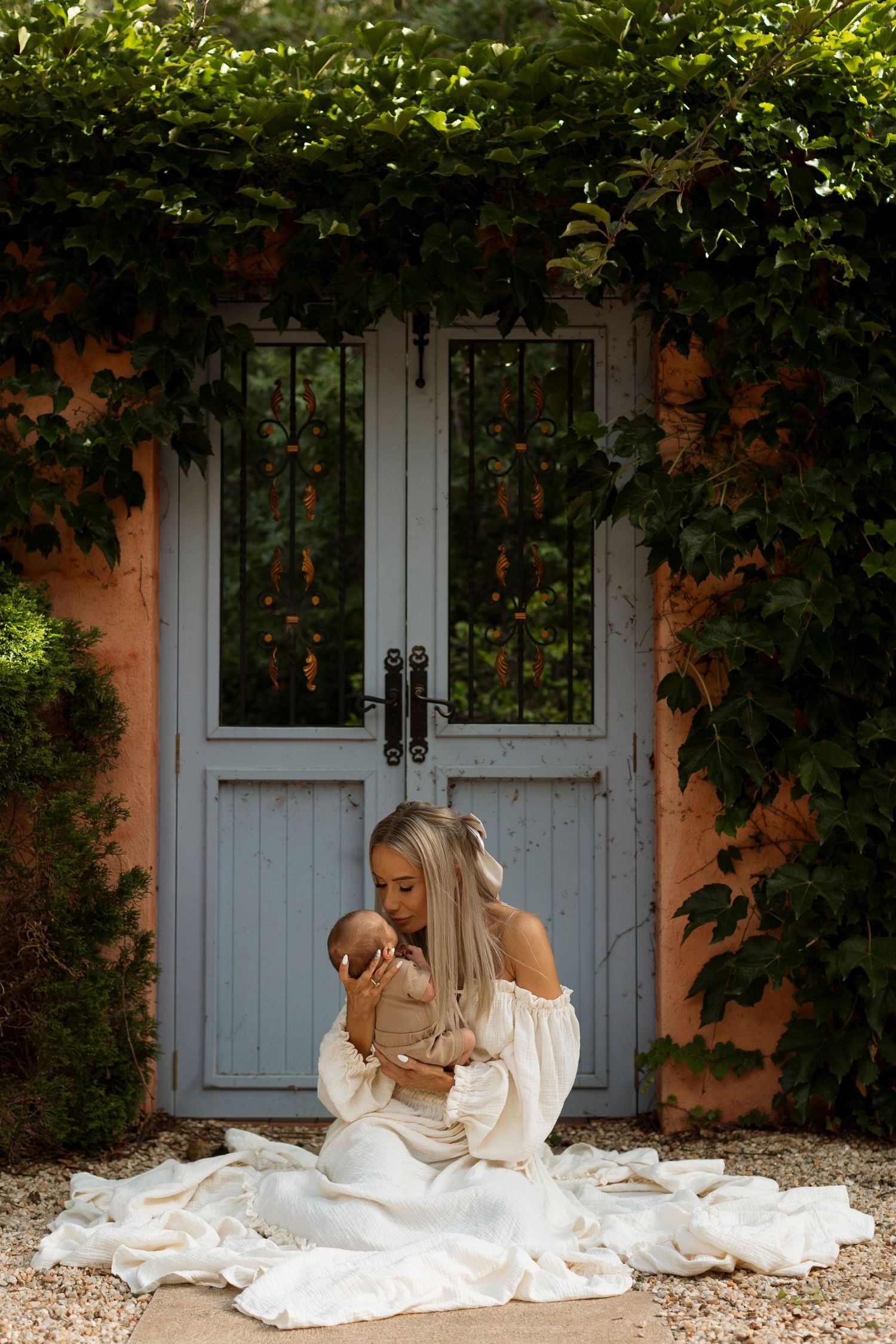 Woman in white dress sitting by blue doors surrounded by green vines in progression shots.