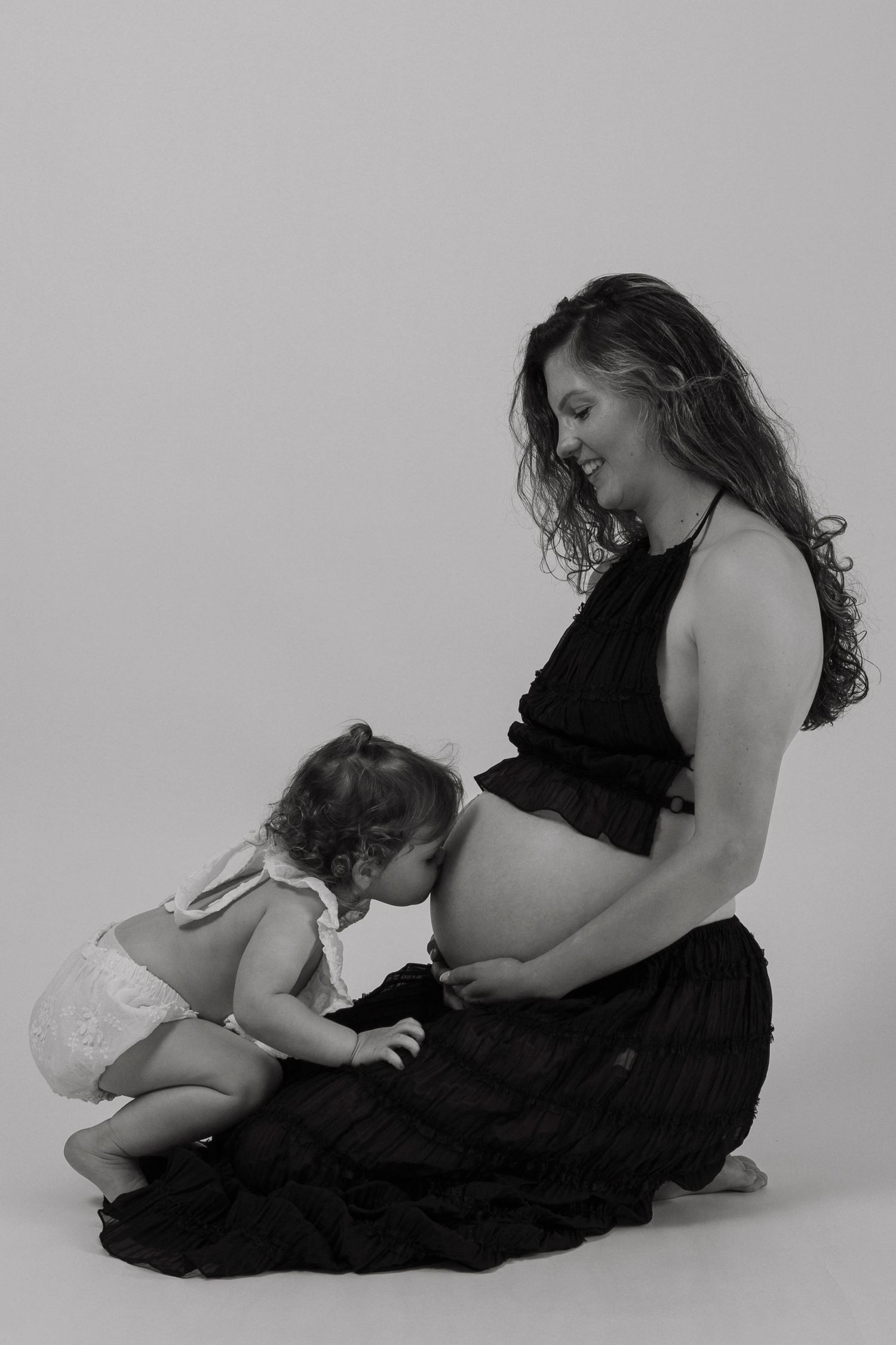 Black and white portrait capturing tender moment between parent and child.