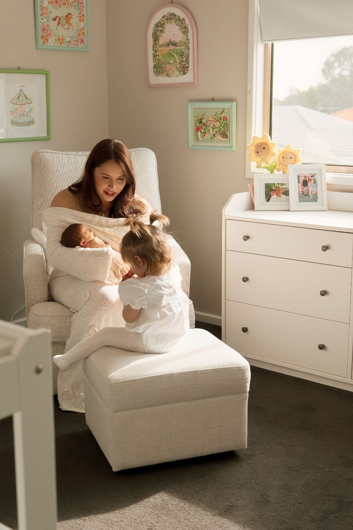 A series of five connected photos showing joyful interaction and play on a white armchair in a nursery room with framed art.